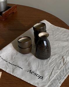 two small vases sitting on top of a piece of paper next to each other