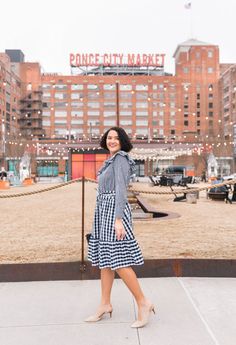 a woman standing in front of a sign that says ponca city market on it