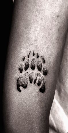 a black and white photo of a paw print on someone's left arm,