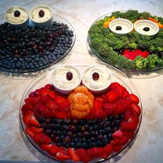 three plates filled with fruits and vegetables shaped like faces