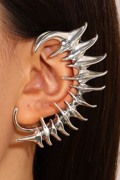 a close up of a person's ear with metal spikes