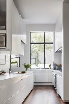 Modern kitchen with white cabinets, stainless steel appliances, and a large window providing natural light. Cozy Breakfast Nook