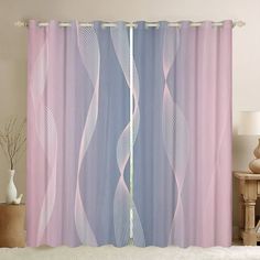 a pink and blue curtain hanging on the side of a wall next to a bed