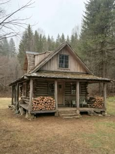 an old log cabin in the woods with logs stacked on the front porch and windows