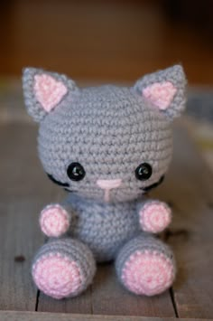 a small crocheted cat sitting on top of a wooden table