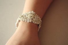 Vintage inspired beading gives a nostalgic picturesque look to every wedding attire. Each piece is carefully handcrafted using opulent swarovski stones and silk thread, making it a perfect heirloom piece. * Bracelet with Swarovski rhinestone and intricate embroidery * Ivory and off-white pearl beading with silver metallic thread work * Length of the beading section is 6.5 inches and width is about 1.5 inches. Fastening/ Finishing options - please mention the option you prefer upon check out. Opt Luxury Pearl Bracelet For Wedding, Elegant Handmade White Crystal Bracelet, Luxury Pearl Bracelets For Wedding, Elegant Jeweled Beaded Bracelets For Gift, Elegant White Beaded Crystal Bracelet, Elegant Jeweled Beaded Bracelets, Elegant Jeweled Bangle Beaded Bracelets, Elegant Jeweled Beaded Bangle Bracelet, Elegant Jeweled Crystal Bangle Bracelet