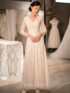 a woman wearing a white dress standing in front of dresses