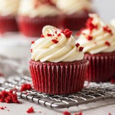 red velvet cupcakes with white frosting and sprinkles