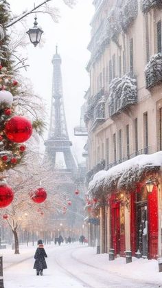 the eiffel tower is covered in snow as people walk down a snowy street