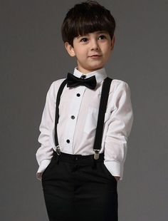 a young boy wearing a white shirt and black suspenders is posing for the camera