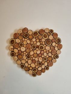 a heart made out of wooden slices on a white wall with the word love spelled in it