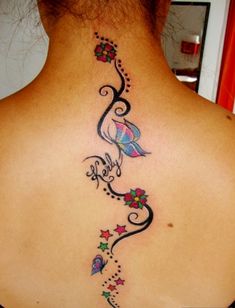 the back of a woman's neck is decorated with flowers and stars on it