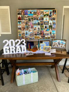 a wooden table topped with lots of pictures next to a wall covered in photos and letters