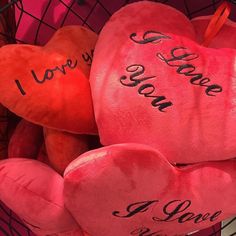 two red hearts with i love you written on them in front of a pink basket