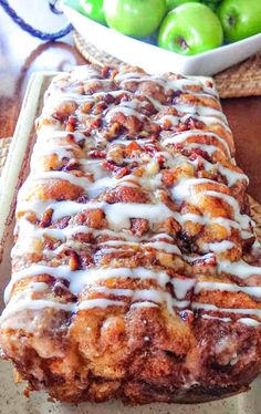 a loaf of cinnamon apple bread sitting on top of a table next to green apples