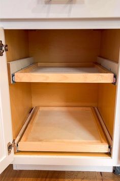 an open cabinet with wooden shelves on the bottom, and drawers in the top right corner