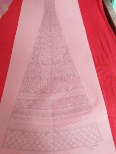 a red table cloth with a drawing of a christmas tree on it and other decorations