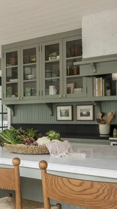 a kitchen filled with lots of green cupboards and counter top next to a sink