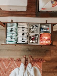 a person's feet are shown in front of some folded books on a bed