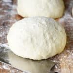 three uncooked doughnuts sitting on top of a table