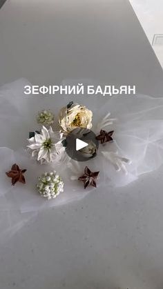 flowers are placed on top of a white surface with words written in russian above them