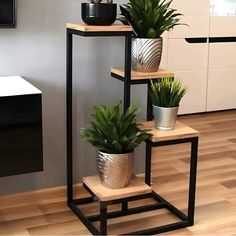 three potted plants sitting on top of each other in front of a wall mounted tv