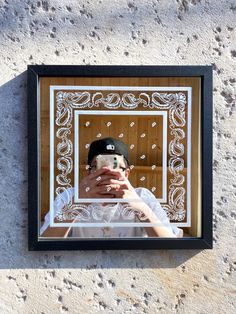 a man taking a selfie with his cell phone in front of a mirror on the wall