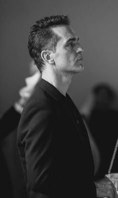 a black and white photo of a man in a suit looking off into the distance