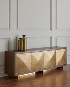 a modern sideboard with gold geometric design on the front and sides, against a white wall