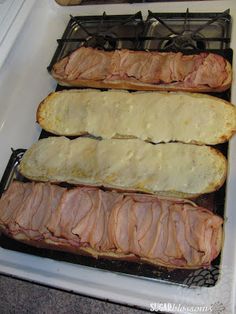 three slices of ham on top of bread in an oven with melted cheese and sauce