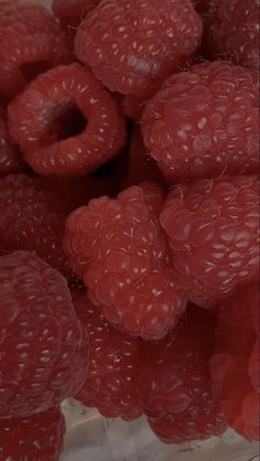 some raspberries are in a white bowl