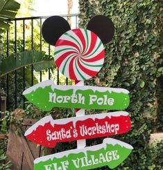 a sign that has some candy canes on it in the shape of mickey mouse