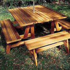 a wooden picnic table with two benches under an umbrella