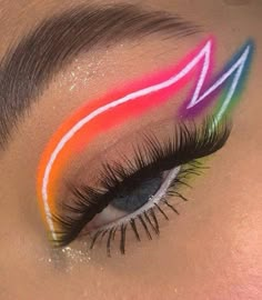 a woman's eye with colorful makeup and long eyelashes on top of her face