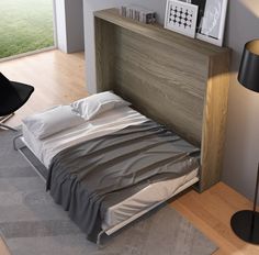 a small bed sitting next to a lamp on top of a hard wood floor in a bedroom