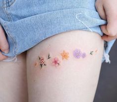 a woman's thigh with flowers painted on it