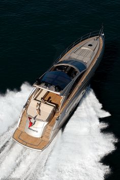 an aerial view of a motor boat in the middle of the ocean with people on board