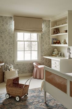 a baby's room with floral wallpaper and a wicker stroller in the foreground