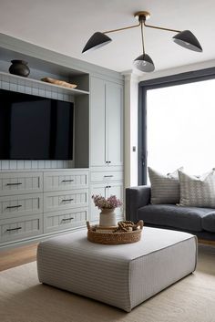 a living room filled with furniture and a flat screen tv mounted on the wall above it