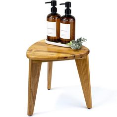 two bottles of soap sitting on top of a wooden stool