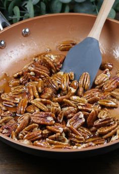 pecans are being cooked in a skillet with a spatula