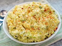 a white bowl filled with mashed potatoes on top of a green and white towel