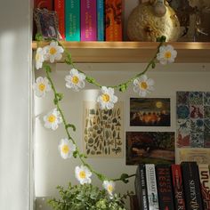 a shelf with books and flowers on it