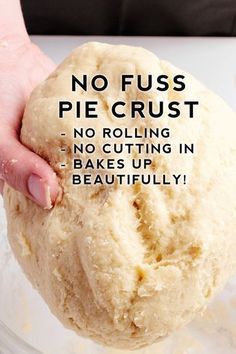 a person holding a ball of dough in their hand with the words no fuss pie crust on it