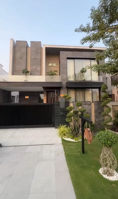 a modern house with an iron gate and landscaping