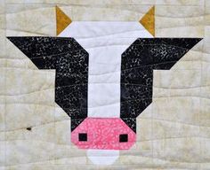 a close up of a cow's face on a quilt