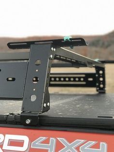 the back end of a red truck with metal brackets on it