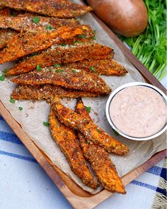 some fried food on a wooden tray with dipping sauce