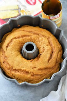 a bundt cake in a pan next to a bottle of beer