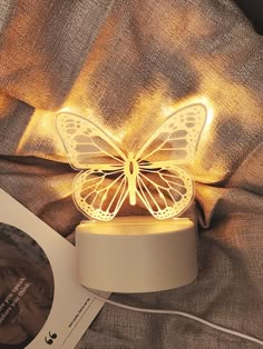 a butterfly shaped light sitting on top of a bed